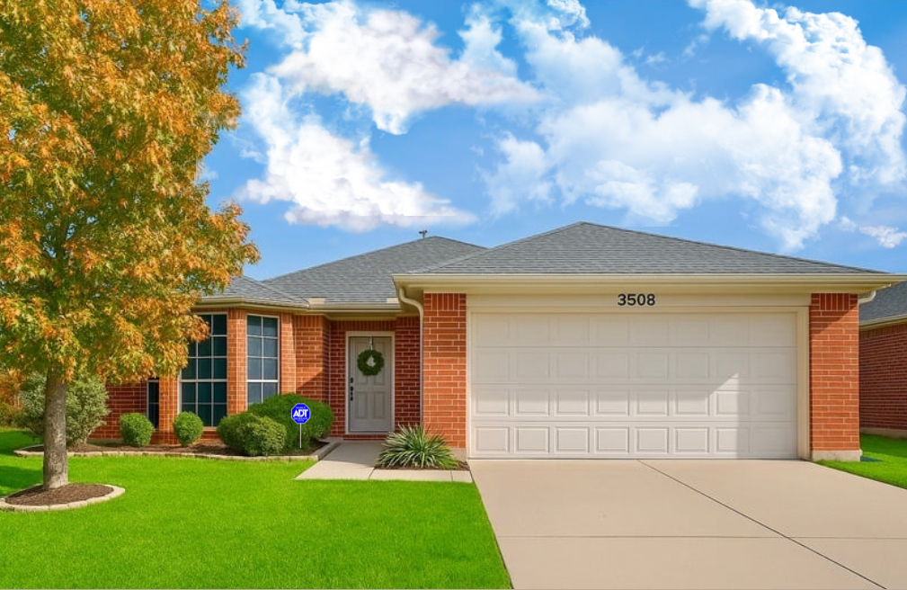 Front of the brick home with autumn tree and green lawn