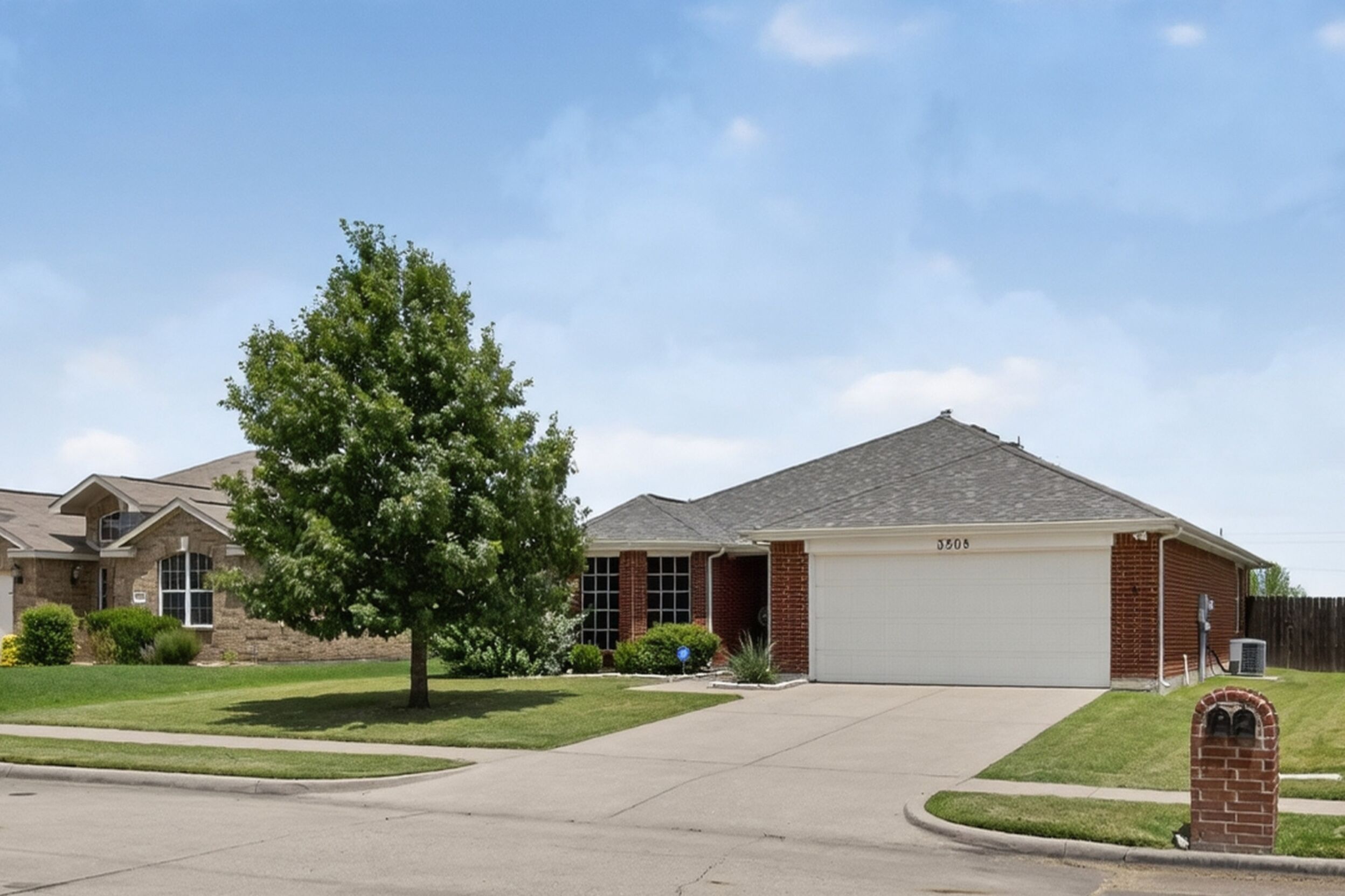 Front exterior of the brick home with attached garage