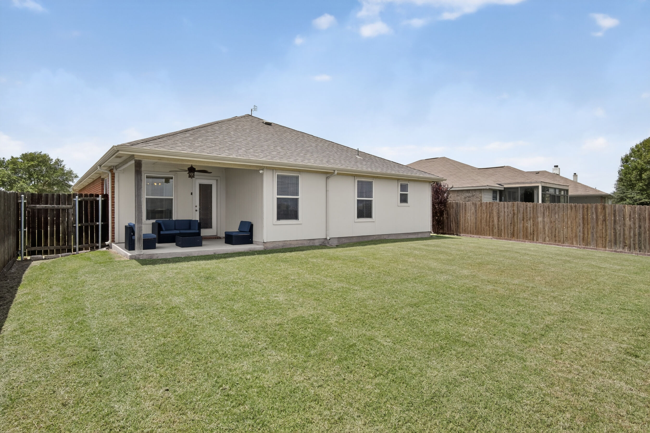 Spacious fenced backyard with covered patio