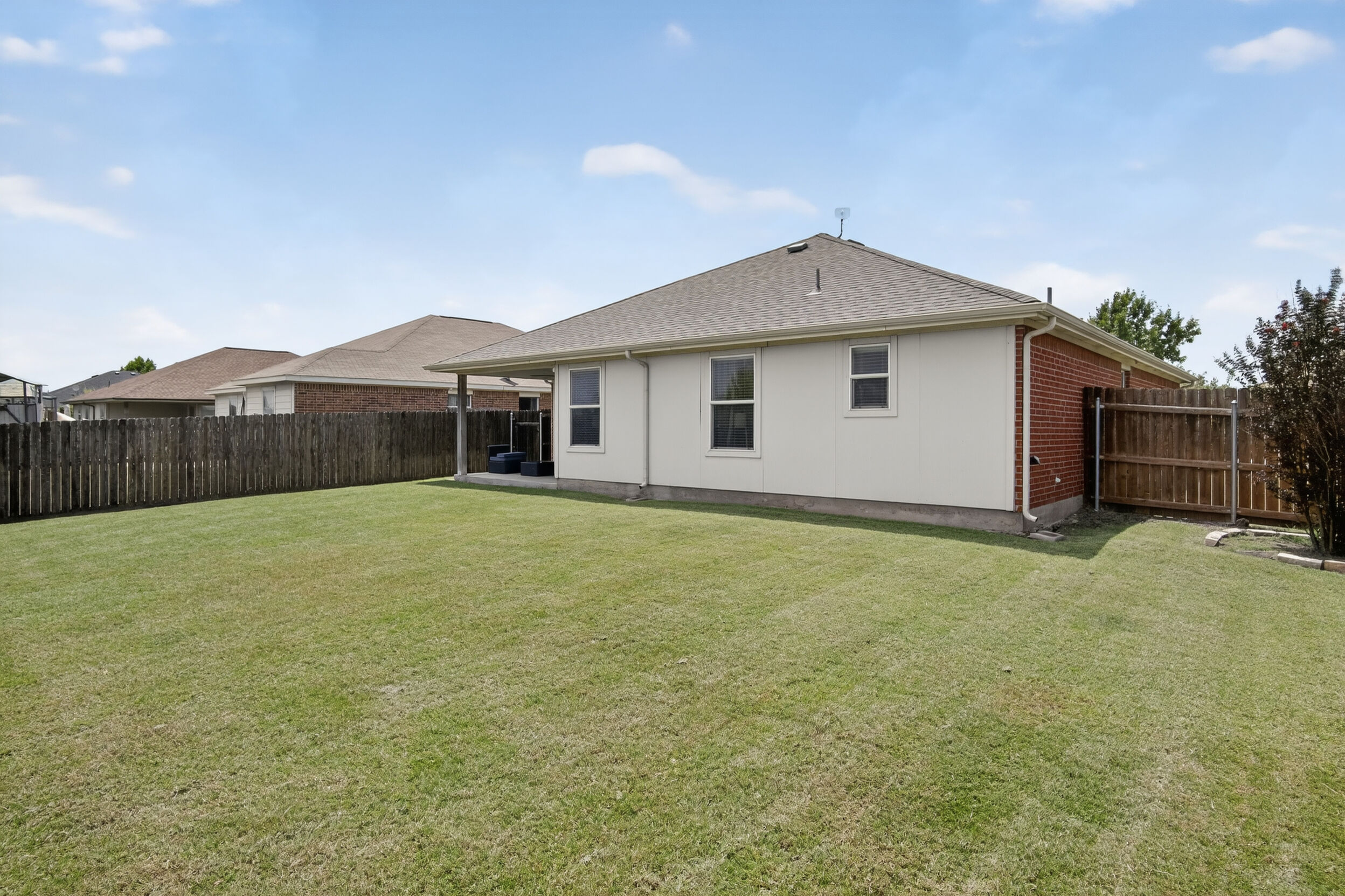 Large grassy backyard with privacy fencing