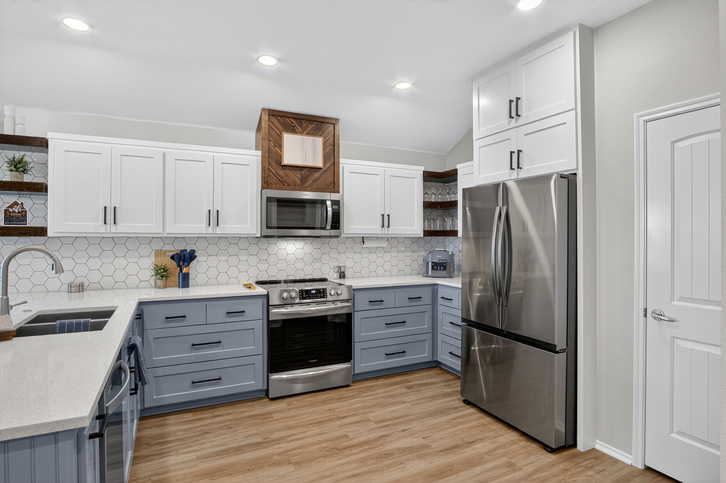 Kitchen with stainless steel appliances and blue cabinetry