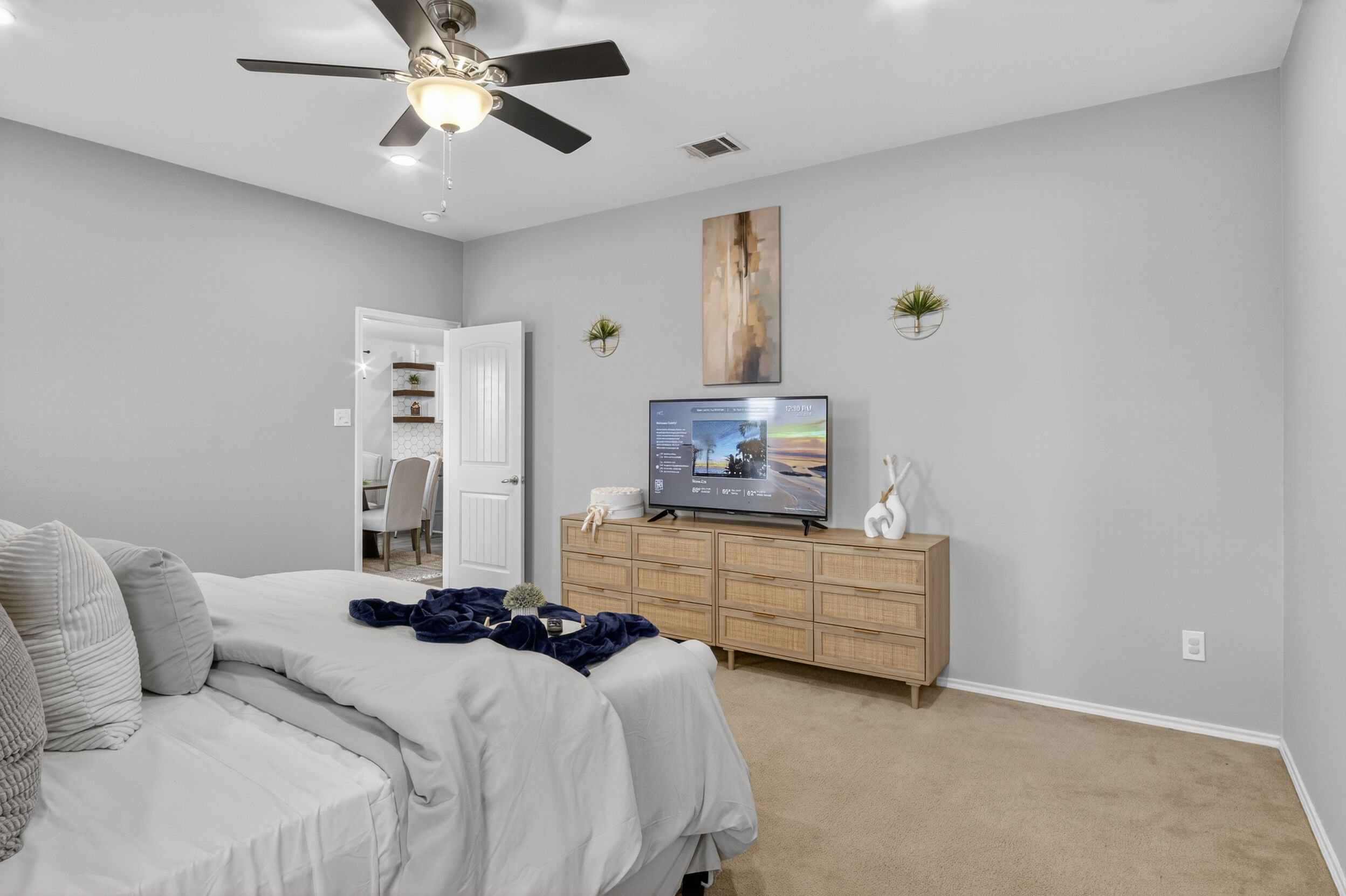 Bedroom with dresser and mounted TV