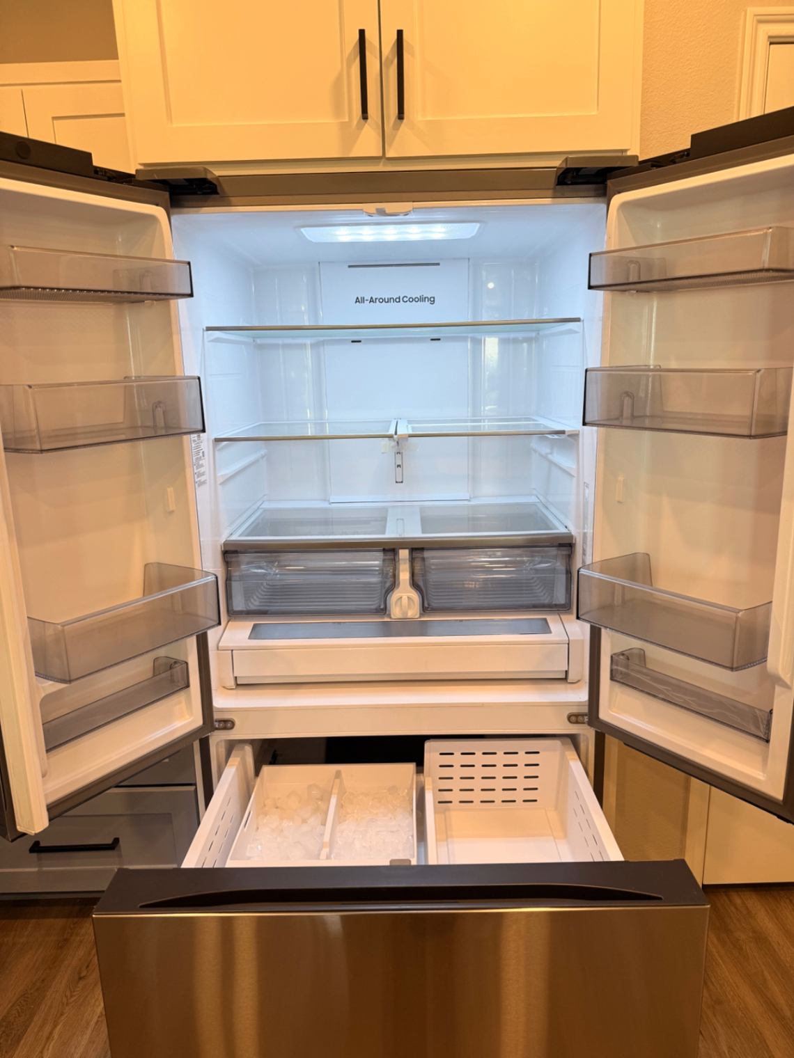 Clean stainless steel refrigerator with ice maker and shelves
