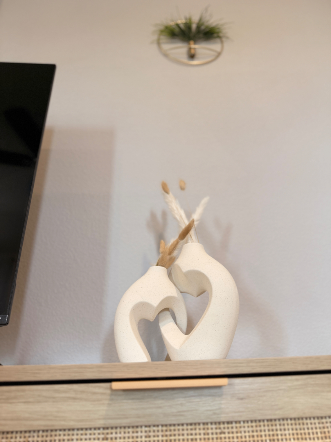 Sculptural white vases with pampas on a bedroom dresser
